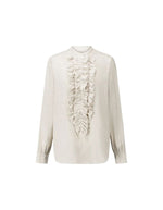 Blouse fluide pour femme en coton beige off white, modèle Carita de la marque Laurence Bras. Présente un col officier, une fermeture boutonnée sous volant et des manches longues froncées.