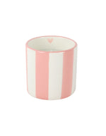 Gros plan sur la Bougie parfumée d'intérieur Chichou de la marque Opjet, présentée dans un contenant cylindrique en céramique blanche de 8 cm de hauteur avec de délicates rayures horizontales rose poudré peintes à la main