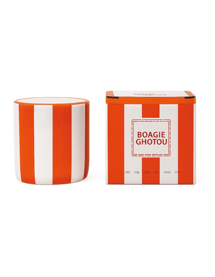 Bougie parfumée d'intérieur Chichou de la marque Opjet, logée dans un contenant cylindrique en céramique blanche de 8 cm de diamètre avec des rayures horizontales orange peintes à la main