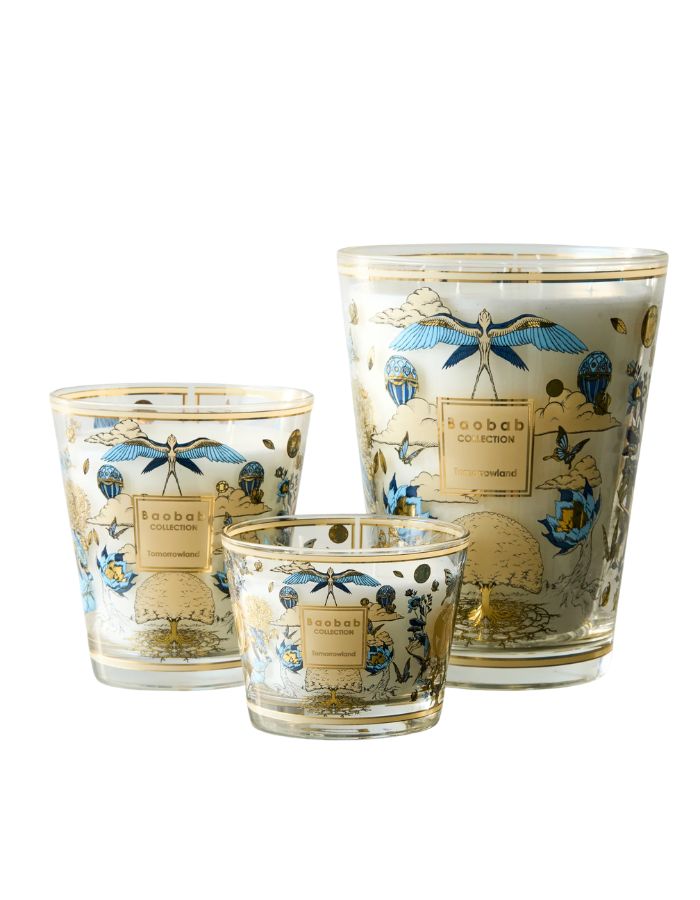 Trois bougies Baobab Collection Tomorrowland 2026 en verre blanc avec motifs dorés et bleus.