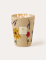 Bougie parfumée de luxe Vony Ahitra modèle max24 par Baobab Collection. Photophore recouvert de raphia naturel avec broderies artisanales colorées représentant des fleurs des champs (coquelicots, lavande). Design textile fait main à Madagascar.