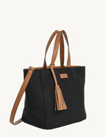 Profil du Sac cabas zippé pour femme en nylon satiné noir avec bandoulière amovible, modèle Cabas Parisien Zippé de la marque LOXWOOD. Présente des anses de porté main, un pompon décoratif et des finitions simili-cuir