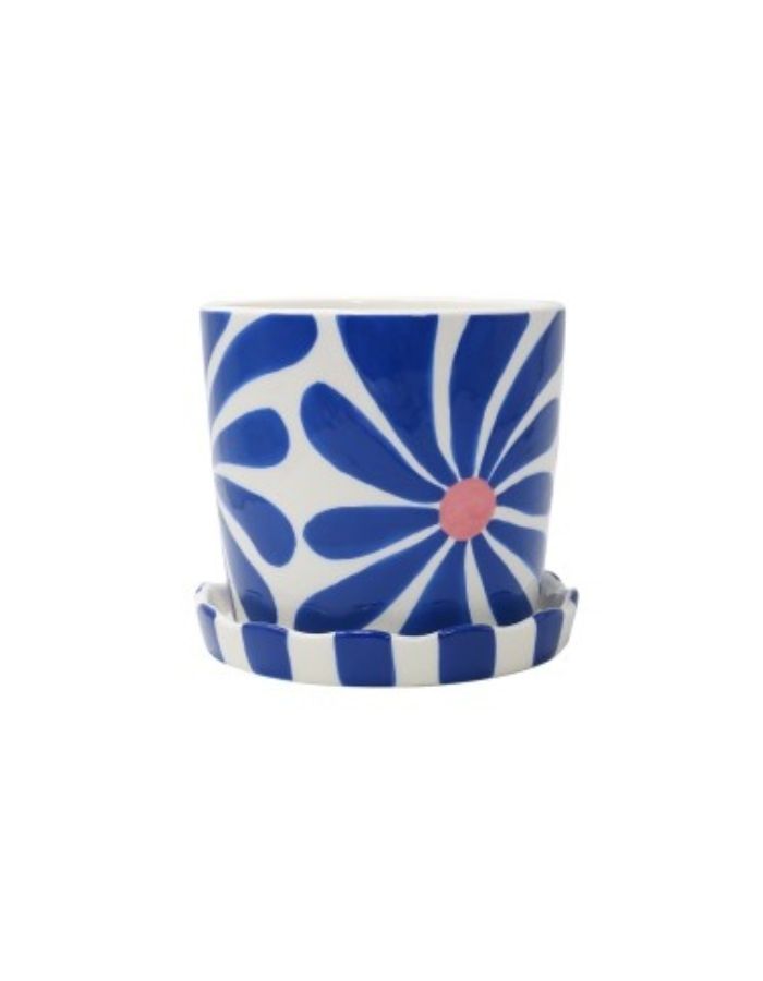 Cache-pot rond en céramique dolomite fait main Lior de la marque Qué Rico, posé sur sa coupelle de drainage assortie. Décoré d'un motif de fleurs graphiques peintes à la main dans des nuances de bleu vif et bleu marine.