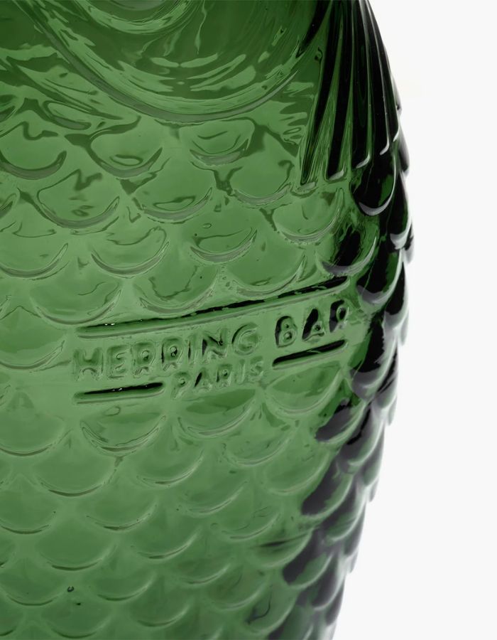 Détail de la Carafe en verre pressé vert foncé sculptée en forme de poisson, design signé Paola Navone