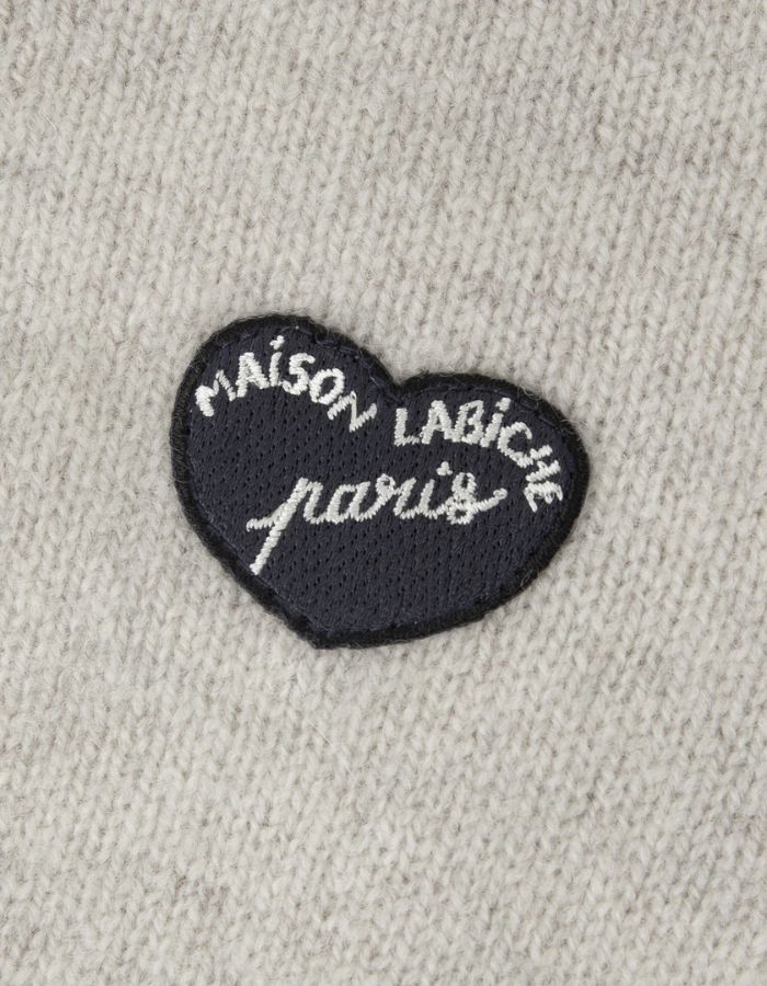 Patch poitrine sur le Cardigan droit boutonné en laine d'agneau couleur gris ciment pour homme avec patch cœur sur la poitrine, modèle Lhomme de la marque Maison Labiche.