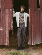 Silhouette avec le Cardigan droit boutonné en laine d'agneau couleur gris ciment pour homme avec patch cœur sur la poitrine, modèle Lhomme de la marque Maison Labiche.