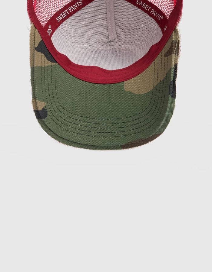 Intérieur de la visière de la Casquette Trucker rouge Candy et blanche Home Run par Sweet Pants. Dotée du patch logo de la marque à l'avant, d'une visière rouge au fini usé sur la tranche et d'un filet de protection blanc respirant à l'arrière.