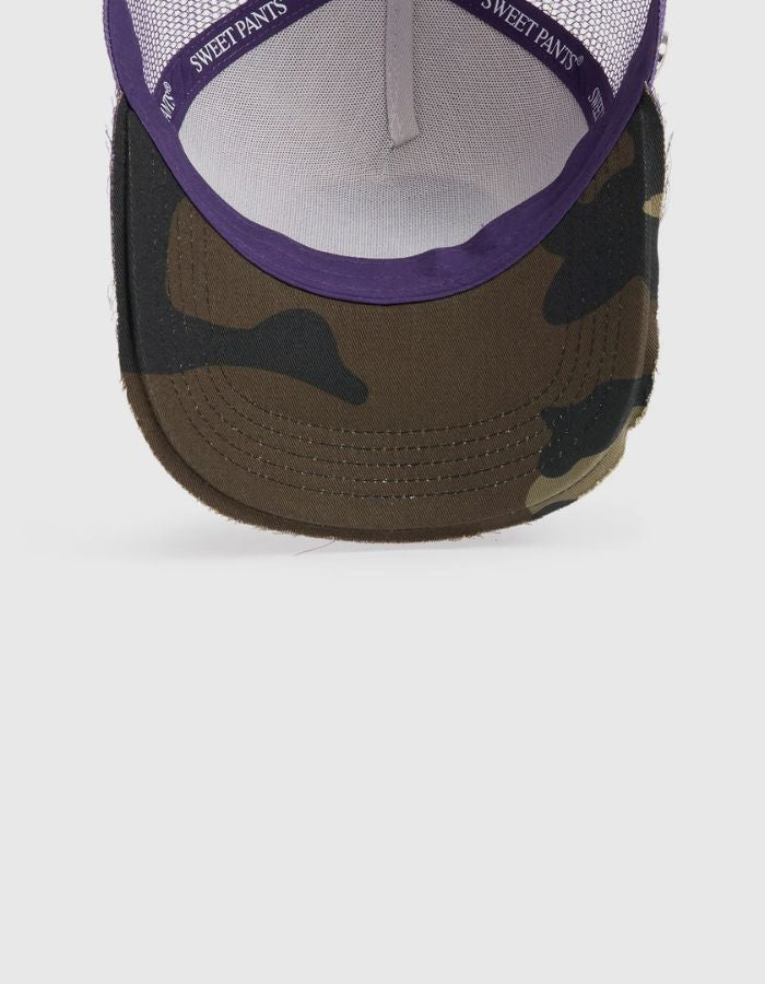 Visiere de la Casquette Trucker bicolore Home Run par Sweet Pants, coloris violet Imperial et blanc. Patch logo de la marque cousu à l'avant, visière violette avec bordure effet usé et panneau arrière en maille filet blanc.