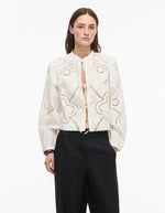 Chemise blanche Carin en popeline de coton bio avec broderie ajourée, col mao et fermeture à liens.