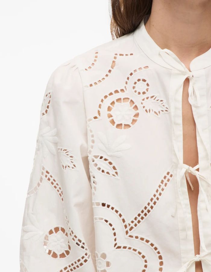 Chemise blanche Carin en popeline de coton biologique avec broderie ajourée, col mao et fermeture à liens.