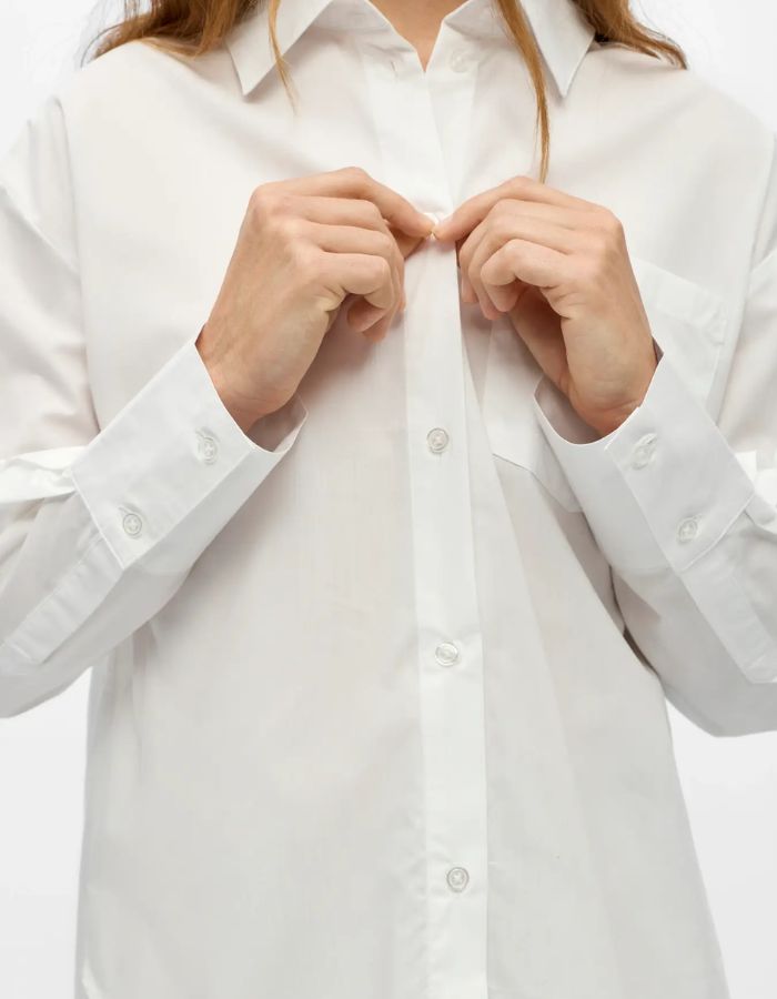 Détail de la Chemise blanche à manches longues pour femme, modèle Zila de la marque Object. Tissu tissé en coton biologique et Tencel avec un imprimé discret sur toute la surface, poche poitrine et col classique.