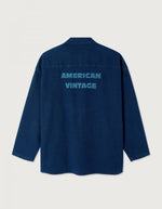 Dos de la Chemise en denim brut bleu foncé pour homme, modèle Comow de la marque American Vintage. Coupe ample et oversize, dotée de manches longues, de deux poches plaquées sur la poitrine et d'un col chemise classique. Au dos, le logo de la marque apparaît discrètement grâce à une finition gravée au laser