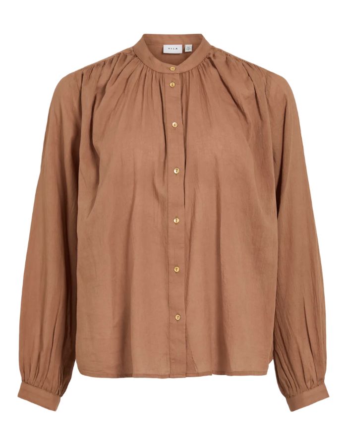 Chemise unie pour femme modèle Esma de la marque Vila. Coupe droite à manches longues en coton bio de couleur marron terracotta clair Nuthatch, caractérisée par un col officier élégant et une fermeture boutonnée.