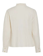 Dos de la Chemise unie pour femme modèle Esma Frill de la marque Vila. Coupe droite à manches longues en coton bio de couleur blanc cassé écru Birch, ornée de volants plissés délicats le long du col et de la boutonnière.