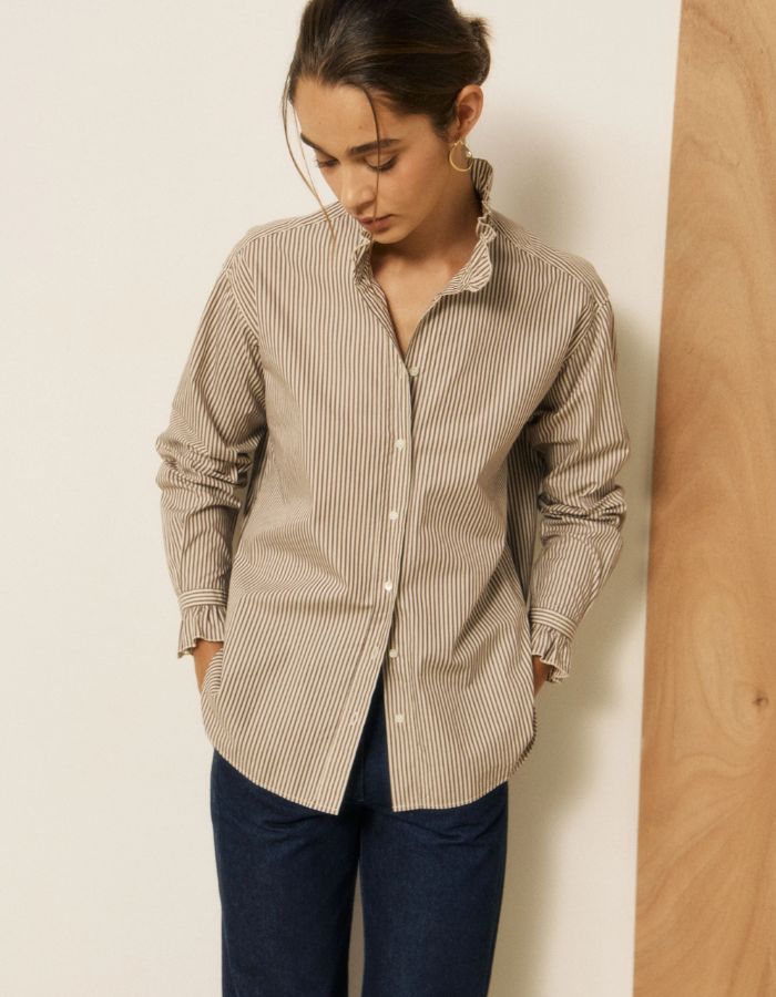 Chemise ample pour femme en coton à rayures marron, modèle Chana de la marque HARTFORD. Présente un col montant et des poignets à volants, des emmanchures tombantes et des boutons en nacre.