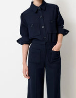 Vue de face de la Chemise courte pour femme en tricotine fluide bleu marine avec poches plaquées boutonnées et plis aux épaules, modèle Chemise Theodore couleur Navy de la marque Sessùn.
