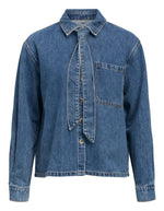 Chemise en jean manches longues pour femme de couleur bleu moyen Medium Blue Denim, modèle Rosie de la marque Object. Confectionnée dans une toile de denim souple, elle présente un col chemise, une fermeture boutonnée, une poche plaquée sur la poitrine et un détail de nœud en tissu délicat.