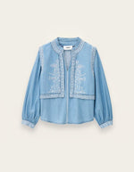 Chemise Laura Ba&sh en chambray denim clair avec effet gilet superposé et broderies blanches.