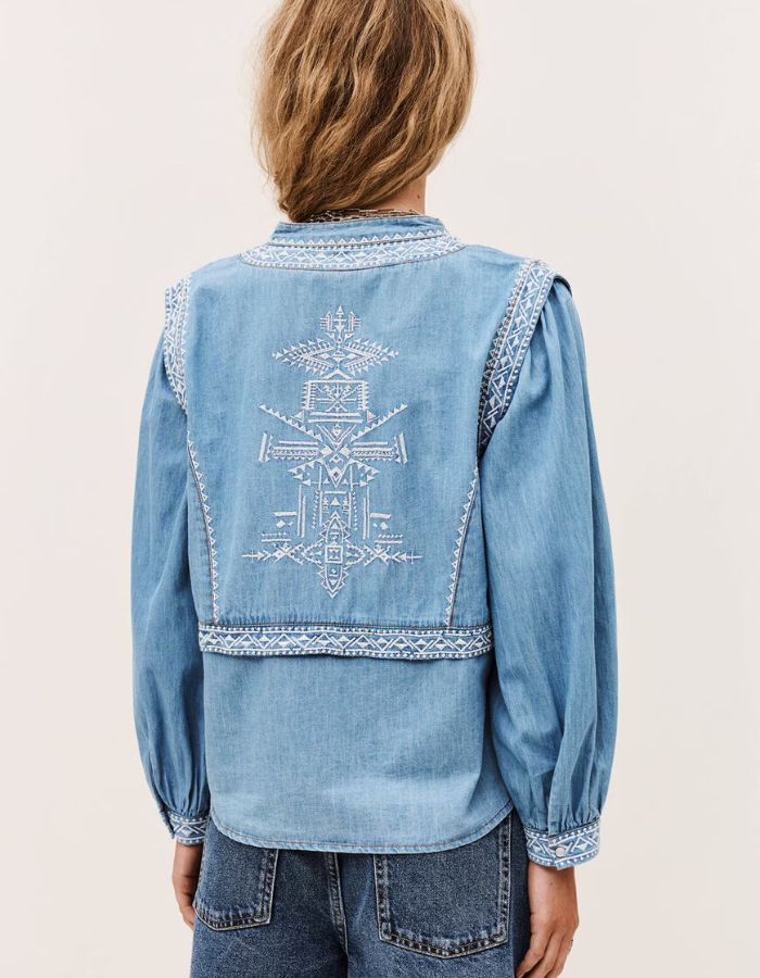 Chemise Laura en denim clair avec effet trompe-l'œil gilet et broderies blanches géométriques au dos.