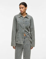 Mannequin portant une chemise en denim gris clair avec col, manches longues, fermeture boutonnée et poche poitrine.