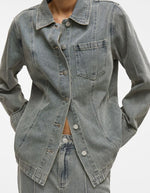 Chemise en denim Vivian bleu clair avec col, manches longues, fermeture boutonnée et poche poitrine.