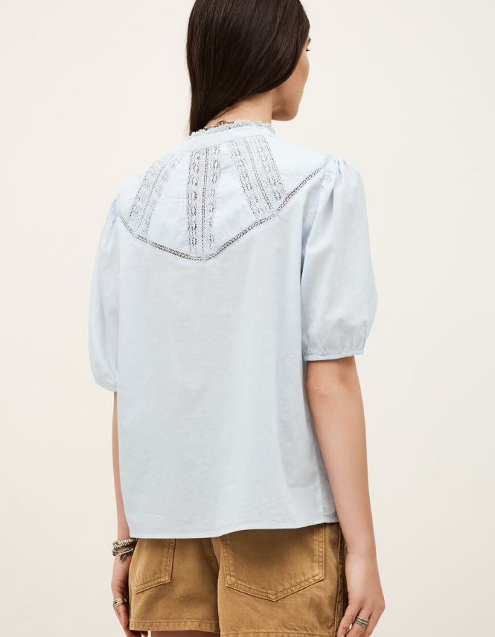 Chemise Nella bleu ciel en voile de coton biologique, manches courtes, volants et incrustations de dentelle.