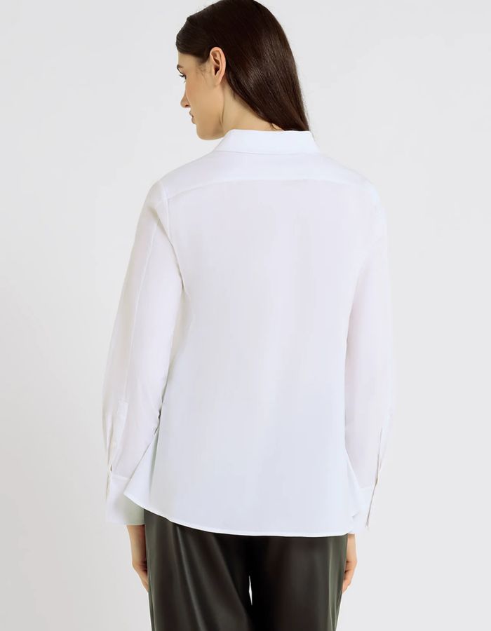Dos de la Chemise évasée pour femme en popeline de coton stretch blanc optique, modèle Dorothea de la marque Hana San. Présente une coupe patineuse, une découpe au dos et des poignets plissés avec boutons en nacre.