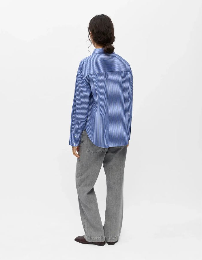 Dos de la Chemise à manches longues pour femme modèle Zila de la marque Object. Tissu tissé fluide à rayures verticales bleu Clématite et blanc, dotée d'un col classique, d'une fermeture boutonnée et d'une poche plaquée sur la poitrine.