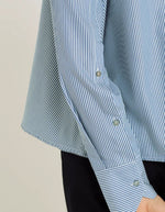 Manche de la Chemise évasée à rayures bleu indigo pour femme, modèle Grace de la marque Hana San. Présente une patte de boutonnage cachée, une emmanchure marteau et de longues pattes poignets boutonnées.