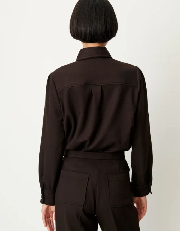 Dos de la Chemise courte pour femme en tricotine fluide couleur ébène avec poches plaquées boutonnées et plis aux épaules, modèle Chemise Theodore couleur Ébène de la marque Sessùn.