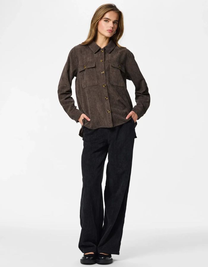 Vue de face de la Chemise ample pour femme en velours côtelé à manches longues, modèle Effi de la marque Pieces. Tissu corduroy de couleur marron foncé chocolat Hot Fudge, avec des poches de poitrine boutonnées et des poignets élastiqués.