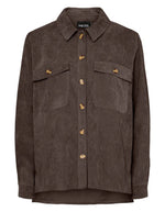 Chemise ample pour femme en velours côtelé à manches longues, modèle Effi de la marque Pieces. Tissu corduroy de couleur marron foncé chocolat Hot Fudge, avec des poches de poitrine boutonnées et des poignets élastiqués.