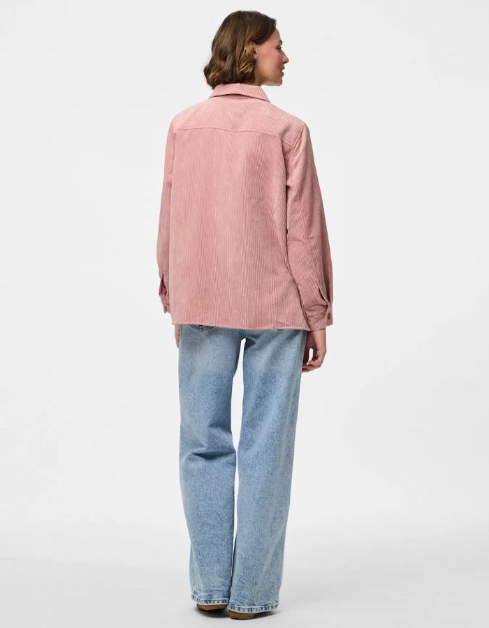 Silhouette de dos avec la Chemise ample pour femme en velours côtelé à manches longues, modèle Effi de la marque Pieces. Tissu corduroy de couleur vieux rose Ash Rose, avec poches de poitrine boutonnées, boutons apparents et poignets élastiqués.