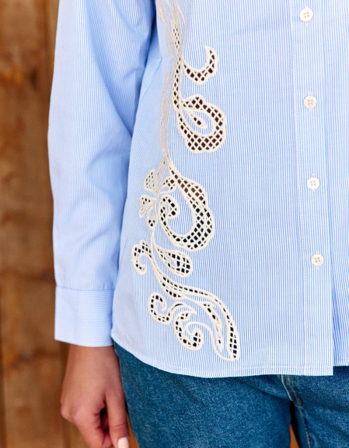 Manche du Chemisier droit pour femme à rayures écru et bleu, modèle Clema de la marque LA PETITE ÉTOILE. Présente un col chemise et une grande broderie ajourée asymétrique sur le devant.