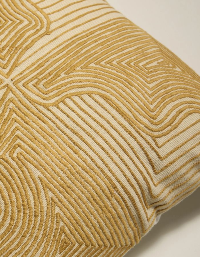 Finition du Coussin carré Onda par Maison Sarah Lavoine. Motif brodé en relief évoquant des ondes, coloris Ocre, mélange coton et laine, dimensions 42x42 cm, fabriqué artisanalement en Inde.