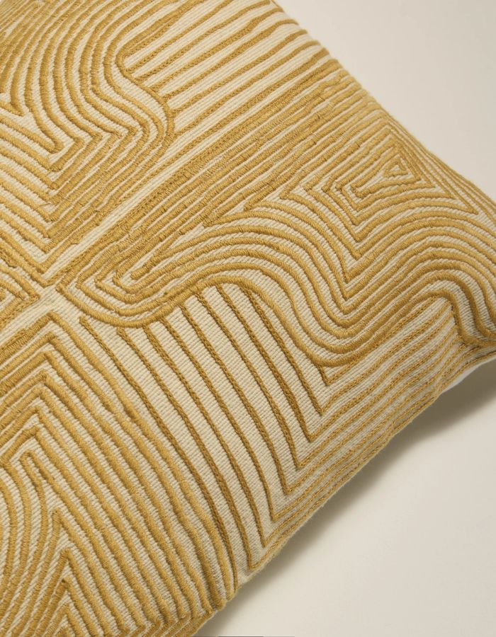Finition du Coussin rectangulaire Onda par Maison Sarah Lavoine. Coloris Ocre avec motifs brodés en relief imitant les ondes de l'eau. Mélange coton et laine, dimensions 50x30 cm, fabriqué en Inde.
