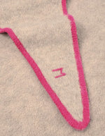Logo sur l'Écharpe triangle pour femme en baby alpaga doux beige avec liseré contrastant rose, modèle Écharpe Elly N°218 Cord Lipstick de la marque MOISMONT.