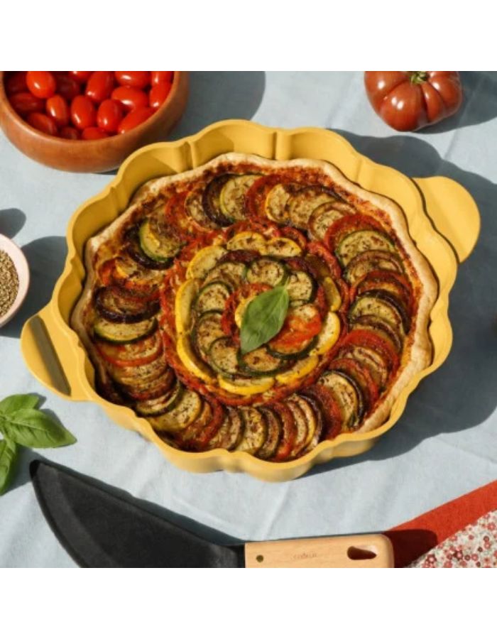 Plat à tarte Cookut 29 cm en métal recyclé avec revêtement antiadhérent sans PFAS et découpe en forme de fleur.