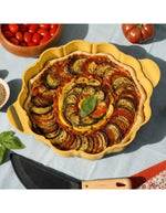 Plat à tarte Cookut 29 cm en métal recyclé avec revêtement antiadhérent sans PFAS et découpe en forme de fleur.