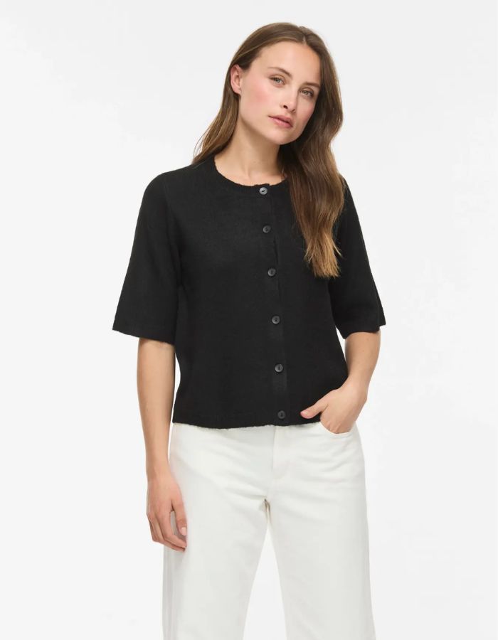 Silhouette avec le Gilet fin en maille pour femme de couleur noir uni Black Beauty, modèle Liga de la marque Vila. Présente un col rond, une fermeture par boutons sur le devant et des manches mi-longues arrivant sous le coude.
