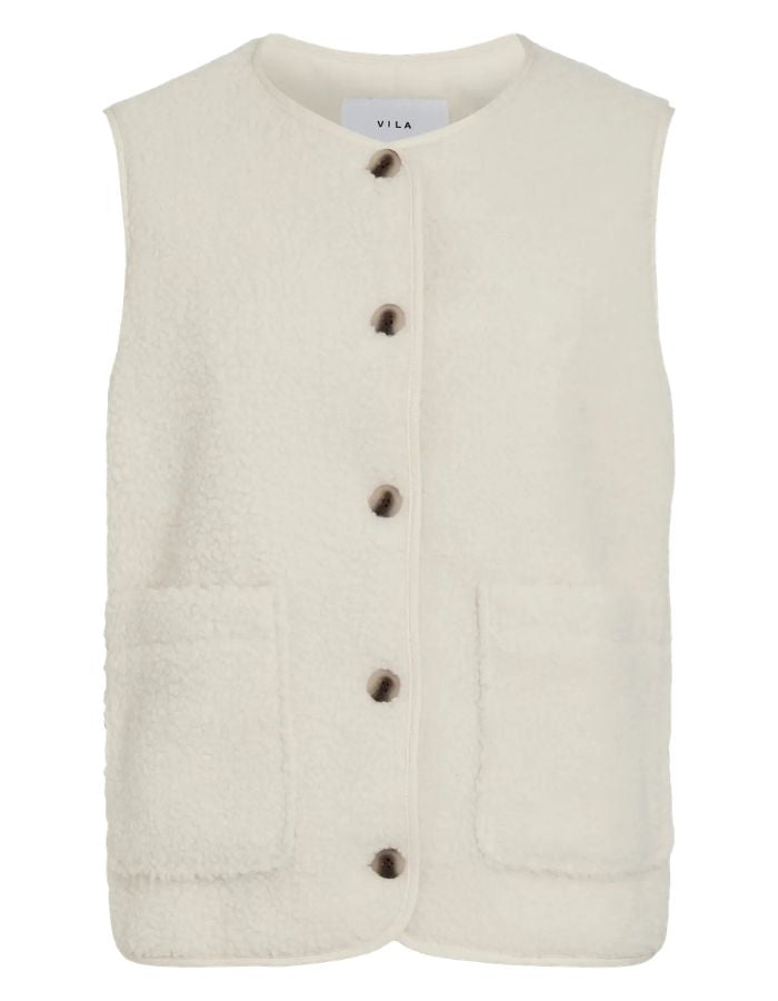 Gilet sans manches pour femme en matière peluche bouclée de couleur beige clair, modèle Ada de la marque Vila. Présente un col rond, une fermeture boutonnée à l'avant et deux poches plaquées.
