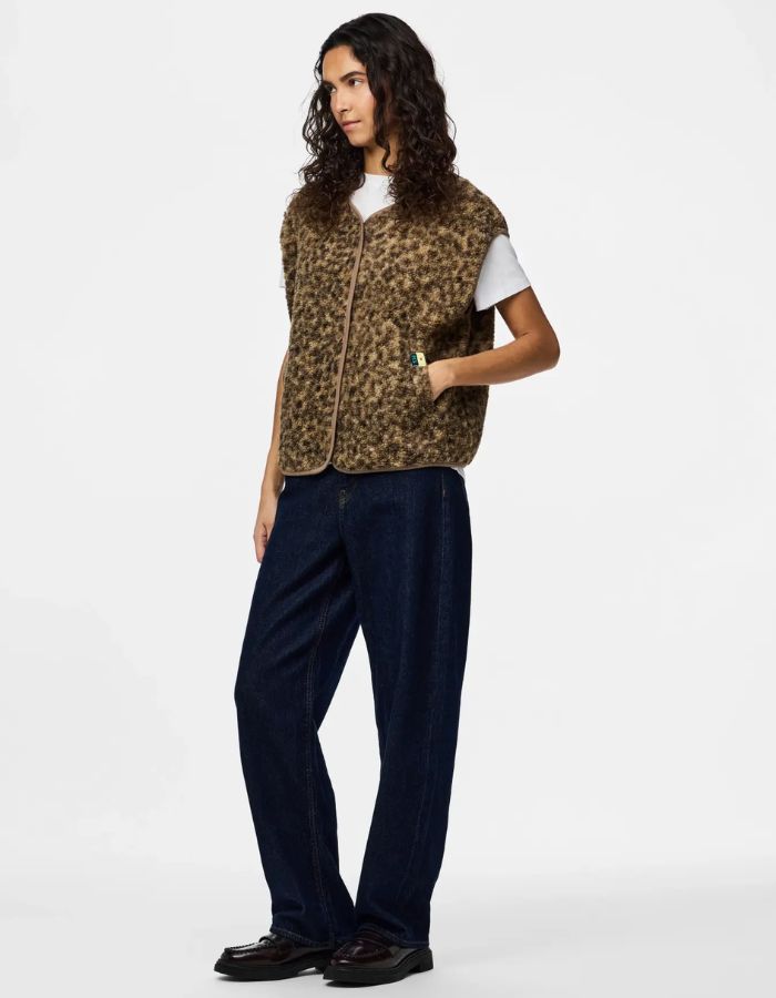 Silhouette avec le Gilet sans manches Katty Teddy pour femme avec imprimé léopard tacheté. Texture polaire bouclée douce, col en V et poches sur les côtés. Veste sans manches tendance en polyester recyclé.