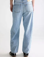 Jean Pacy N°55 loose en denim bleu clair effet bleach, taille basse, jambes larges et coutures apparentes.