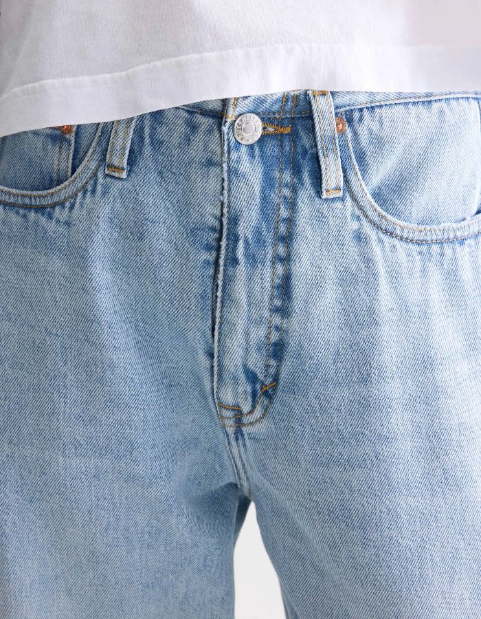 Jean Pacy N°55 loose en denim bleu clair effet bleach, taille basse, coutures apparentes.