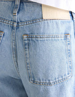 Jean loose femme bleu clair effet bleach, taille basse, avec poche arrière et étiquette Bellerose.