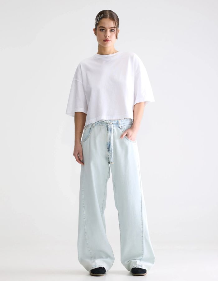Jean Pearcy n65 Ice Bleach ample et taille basse avec cordon, porté avec un t-shirt blanc.