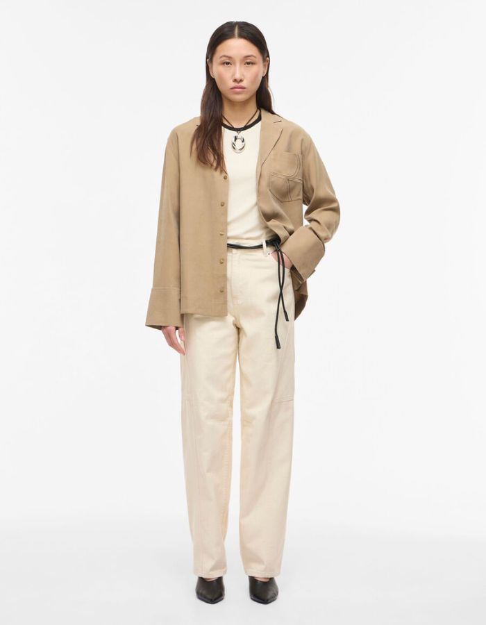 Silhouette avec le Jean femme coupe tonneau de la marque VILA, coloris Birch (blanc cassé). Taille mi-haute, modèle cinq poches en coton mélangé recyclé avec une silhouette structurée.