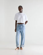 Femme portant un jean DENIM N.46 bleu clair délavé, coupe large, taille mi-haute, ourlets retroussés.