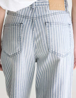 Jean denim bleu délavé à rayures verticales écru, coupe relaxed boyfriend, taille mi-haute.