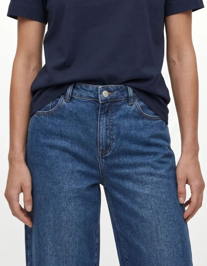 Ceinture du Jean large pour femme de couleur bleu moyen délavé Medium Blue Denim, modèle Rio Mae de la marque OBJECT. Présente une taille mi-haute, des jambes larges amples, une fermeture à bouton et zip et un style cinq poches classique.